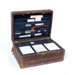 A Victorian leather dispatch and writing case, the fitted interior with ceramic diary tablets, ink