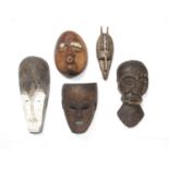 Tribal interest, a group of five masks, all carved wood including a fang mask with white pigments