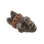 An African wooden Aanang Ekpo puppet mask with moveable jaw, the horns with red pigment, 20cm