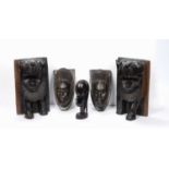 A West African ebony carved wood head, and two simlar, together with a pair of carved wood lion