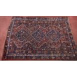 A Persian Khamseh small carpet with a central interlocking row of diamond medallions on a blue and