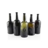 A group of five sealed wine bottles, cylinders, each seal stamped A.S.C.R. (All Souls Common