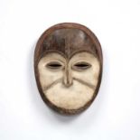 An African, Gabon, Adouma Duma mask, carved wood with incised decoration and white pigments, 26cm