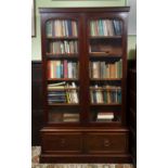 A Victorian mahogany bookcase, the upper section with a pair of arch glazed doors and shelving,