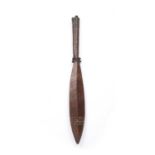 A polynesian paddle shaped club, carved wood with tapered handle and incised with geometric designs,