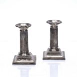 Matched pair of silver Corinthian column candlesticks with loaded bases, bearing marks for William