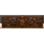 A renaissance style walnut carved wall panel the central armorial crest surrounded by acanthus