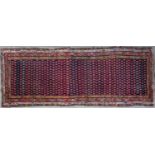 An antique Hamadan red and blue ground rug with a multiple banded borders and central repeating