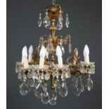 A gilt metal and cut glass three branch electrolier each branch with three lights surrounded by