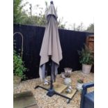 A Kettler garden parasol on metal stand, with inset paving slabs, the base measuring 108cm wide x