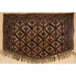 An antique Yomut Asmalyk rug with a repeating pattern decoration and tassels, 125cm x