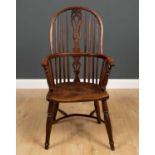 An early 19th century high hoop back Windsor armchair with a yew wood pierced splat, spindles and