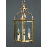 A brass hexagonal hall lantern with scrolling supports to the top, bevelled glazing and six light