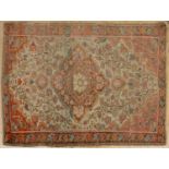 An early to mid 20th century Middle Eastern red and white ground rug with a central motif and