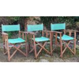 A set of three foldable garden chairs with hardwood wooden frames and green canvas seats and