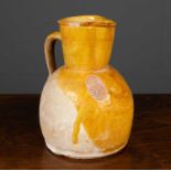 A late 19th / early 20th century French mustard glaze terracotta jug with looping handle, 17cm