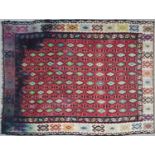 An Anatolian Kelim flat weave rug with a red central ground and a cream border, 309cm x