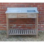 A pine potting table with zinc top, with sloped recessed compartment over single drawer and