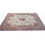 A late 20th century Persian style red and cream ground carpet with a multiple banded border and
