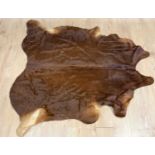 A modern brown cow hide rug of shaped outline, approximately 196cm x 190cmCondition report: Marks