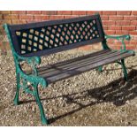 A cast iron framed two seater garden bench with green painted scrolling frame and latticework back