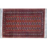 A late 20th century Tekke Turkaman style red ground rug 180cm x 123cm together with a small