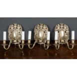 A set of three two branch metal wall lights the silvered back plates decorated with a pair of