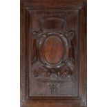 An oak armorial carved panel the central shield flanked by curtains within bevelled frame, 41cm wide