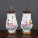 A pair of Asian ceramic vases converted into table lamps, the white ground decorated with flowers