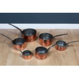 A set of five copper pans with wrought iron handles, stamped to the side 28, 24, 22, 20 and 18,