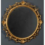 A19th century carved giltwood circular mirror frame of scrolling acanthus leaf and scallop shell