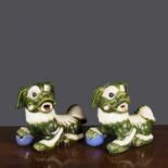 Two similar Chinese ceramic dogs of fo with green and white painted and engraved decoration, 28cm