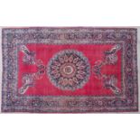 A mid 20th century Khurasan red ground rug with a central circular motif with stylised floral