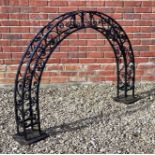 A black painted metal garden arch with scrolling decoration on square bases, 147cm wide x 23cmm deep