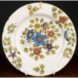 A Fazakerley Delftware plate, with purple, blue, ochre and puce flower and foliate decoration,