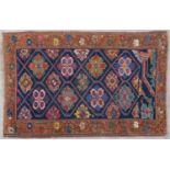 An early 20th century North West Persian Heriz rug with central blue ground with multiple flowerhead