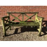 A modern two seater garden bench of rustic form by Eynsham Park Sawmill, with cross decoration to