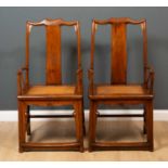 A pair of antique Chinese elm Officials hat chairs with inset rattan seats and scrolling ornament to