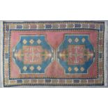 A 20th century Turkish blue and red ground rug with two large central motifs with archaic decoration