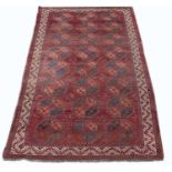 An antique Ersari red ground carpet with twenty four octagonal motifs and a banded border, 426cm x