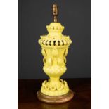 An Italian yellow pottery table lamp in the form of a classical vase with applied moulded leaves and