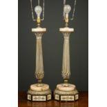 A pair of gilt metal and onyx table lamps of column form with acanthus leaf decoration and shaped