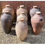 Seven Greek Pithoi type jars each with wooden covers, the largest 40cm diameter x 82cm highCondition