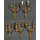 Five gilt metal twin branch wall lights of scrolling acanthus leaf form, each 32cm wide x 55cm
