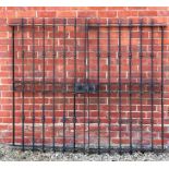 A pair of French black painted wrought iron gates with turned decoration to the bars and central