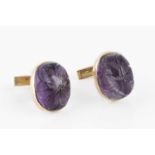 A pair of amethyst cufflinks, each oval amethyst cabochon with floral carved decoration, in collet