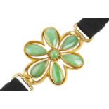 A jade panel bracelet, designed as a convex openwork flowerhead panel, with a cluster of round and