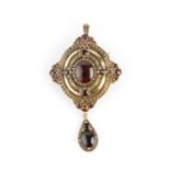 A garnet set pendant/brooch, the shaped oval panel with bead accents, centred with an oval