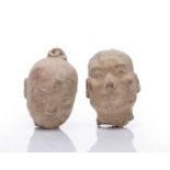 Two clay heads Chinese, Western Han period probably depicting warriors, both wearing a headpiece,