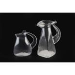 Steven Newell (b.1948) Two jugs, 1984 clear glass signed, one dated largest 22.5cm high.